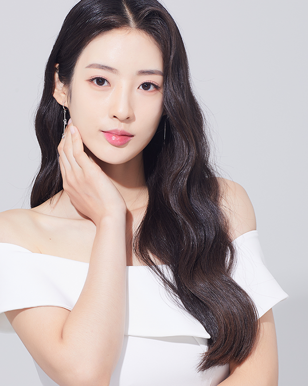 白いドレスを着た、黒髪の女性が顔に手を当てている。