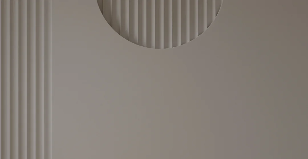 ベージュ色の壁に垂直の線と半円の装飾